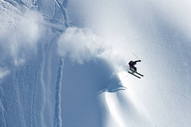 Man athlete doing skiing stunts on sunny alpine slopes stock photo