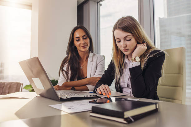 istock Two businesswomen reading documents using tablet computer sitting at desk in modern office 903417710