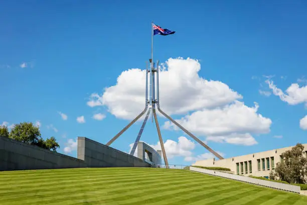 Australian Flag on steel spire at the Australian 'New' Parliament House, the meeting place of the Parliament of Australia. Capital Hill, Canberra, Australian Capital Territory, Australia
