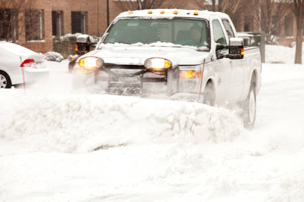 Elmwood Park, NJ, USA – January 4, 2018: Snow plow plowing parking lot at apartment complex during a severe blizzard.