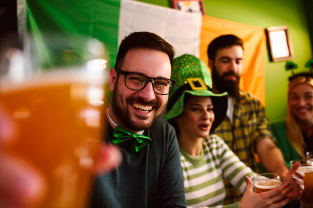 grupa przyjaciół świętujących dzień świętego patryka w beer pub - st patricks day irish culture pub clover zdjęcia i obrazy z banku zdjęć