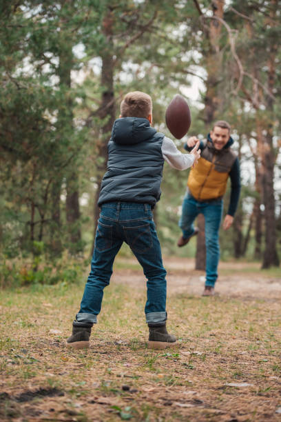 istock father and son playing with ball in forest 903431958