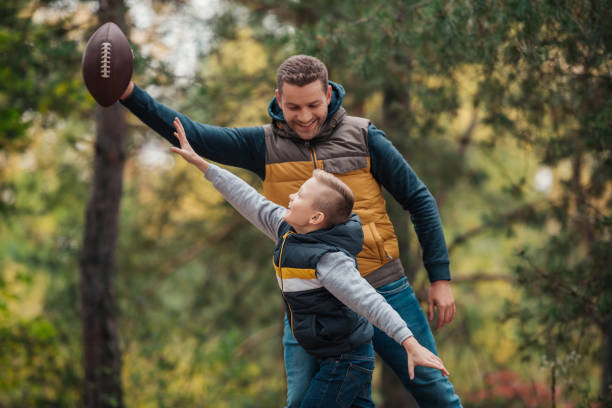 istock father and son playing with ball in forest 903432148