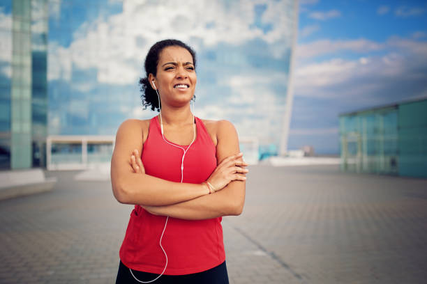 istock Runner girl is resting along the beach after a long run 903438358