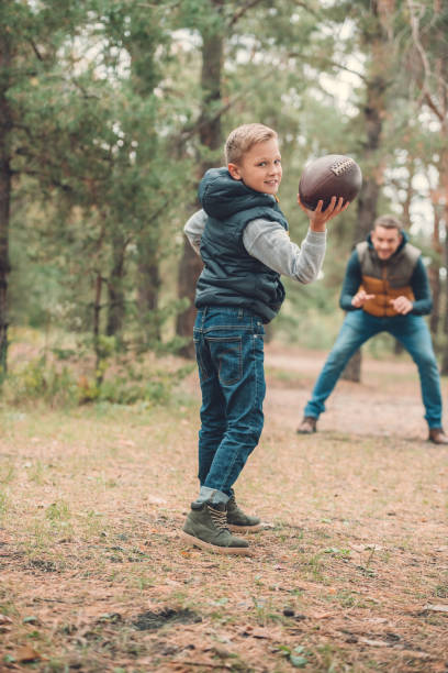 istock father and son playing with ball in forest 903440952