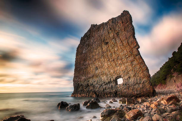 Vertical cliff with hole inside named Skala Parus on the coast of Black Sea. Gelendzhik district, Russia. Long exosure.