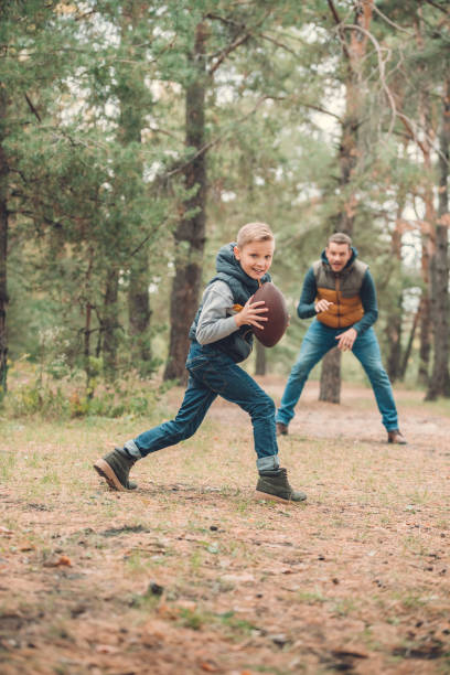 istock father and son playing with ball in forest 903443366