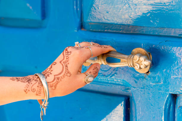 woman hands with brown mehndi tattoo and blue door in india - henna tattoo indian culture tattoo hinduism imagens e fotografias de stock
