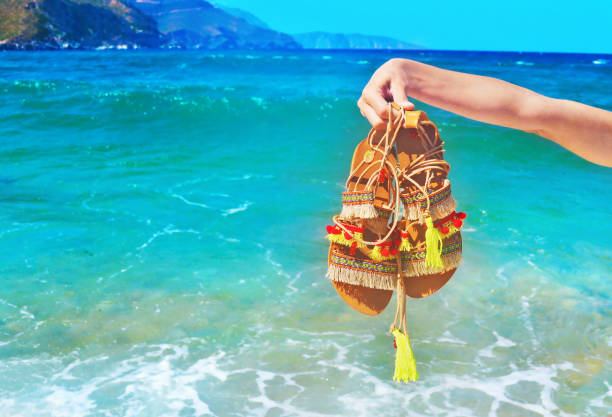 bohemian greek sandals on the beach bohemian greek sandals on the beach - summer shoes advertisement gladiator shoe stock pictures, royalty-free photos & images