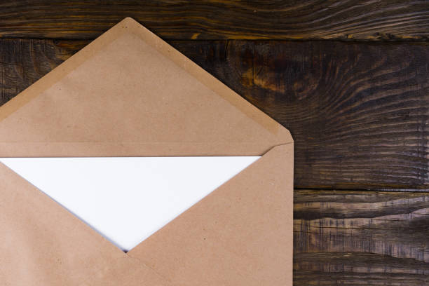 istock Envelope nested in it leaves lying on vintage wooden table. A place for your inscriptions. 903453206