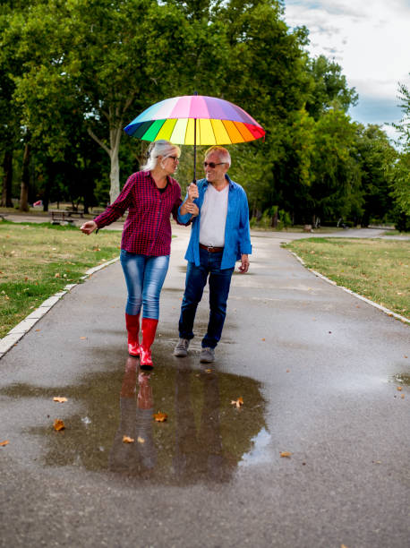 istock The old couple in the rain with umbrellas 903453972