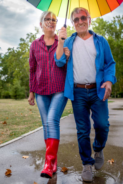 istock The old couple in the rain with umbrellas 903454112