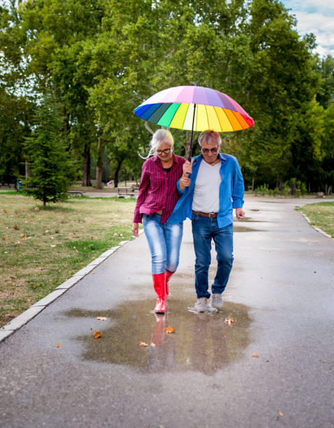istock The old couple in the rain with umbrellas 903456232