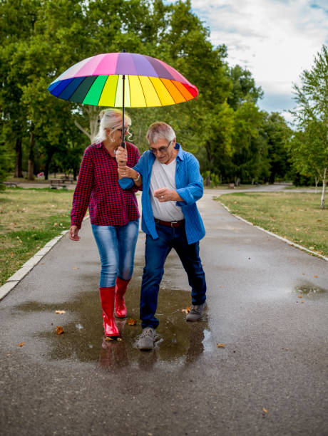 istock The old couple in the rain with umbrellas 903456718