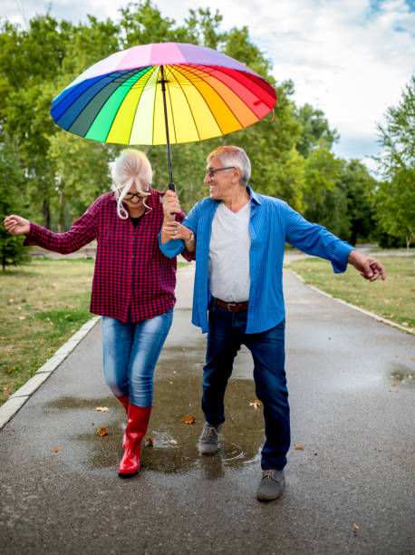 istock The old couple in the rain with umbrellas 903456872
