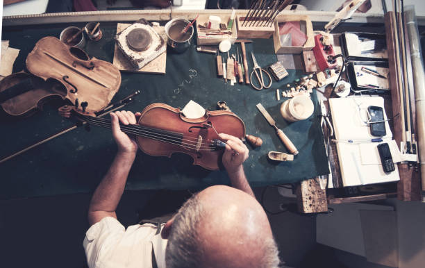 uomo anziano che lavora in officina - workshop old fashioned old instrument maker foto e immagini stock