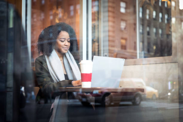 Young woman working on the move at cafe