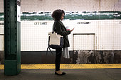 istock Young woman waiting for the subway train in New York 903465518