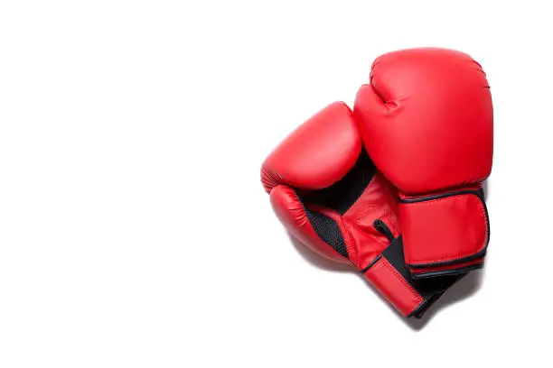 Photo of Leather box equipment for fight and training. Pair of boxing gloves lying on each other. Combat and fight concept. Boxing gloves in red color isolated on white background