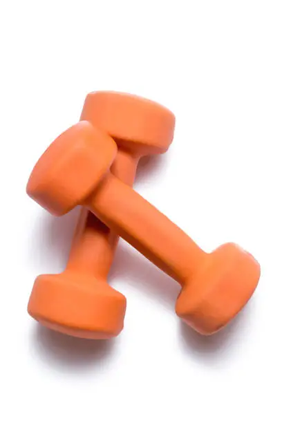 Two orange dumbbells lie on top of each other on a white background.