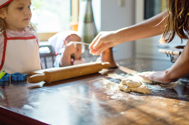 istock Young family cooking in kitchen. Teaching to bake pastry 903475462