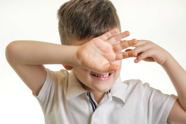 istock Studio shot of young boy, headshot, facial expression, face covered by hands 903482608