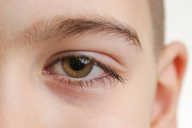 istock Close up view of a green boy's eye looking at camera 903483436