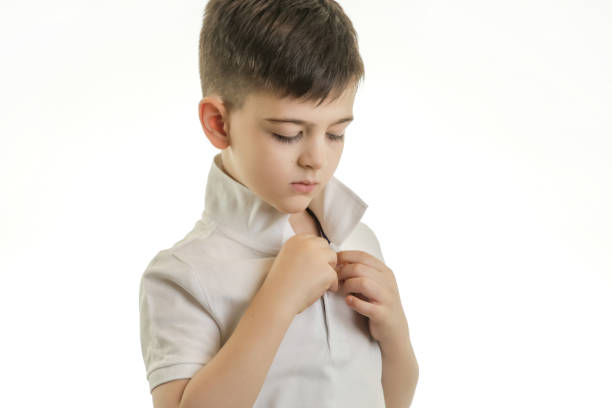 istock Studio shot of young boy buttonong his polo shirt 903483732