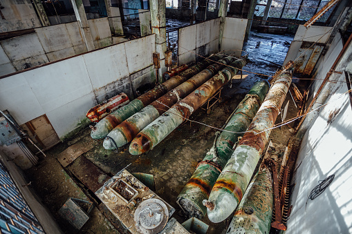 Old rusted submarine torpedoes in abandoned torpedo factory. Top view