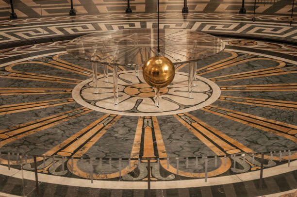 View of the famous Foucault Pendulum copper ball swinging inside the Pantheon in Paris. Paris, northern France - July 12, 2017. View of the famous Foucault Pendulum copper ball swinging inside the Pantheon in Paris. Known as one of the most impressive world’s cultural center. pendulum stock pictures, royalty-free photos & images