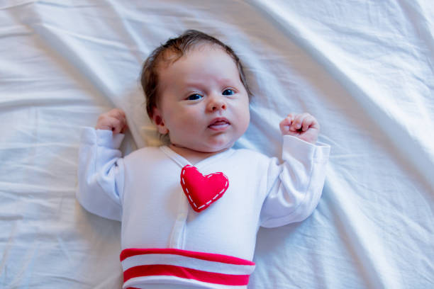istock Little infant with heart shape toy on chest 903495172