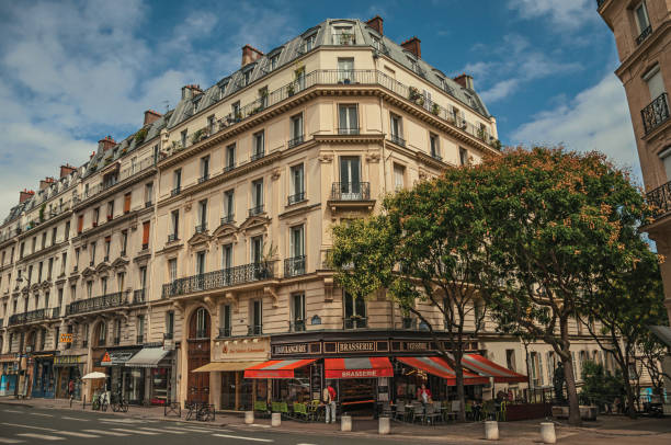 Street with bakery on a corner in a typical Parisian old building. Paris, northern France - July 12, 2017. Street with bakery on a corner in a typical Parisian old building. Known as the “City of Light”, is one of the most impressive world’s cultural center. city street street corner tree stock pictures, royalty-free photos & images