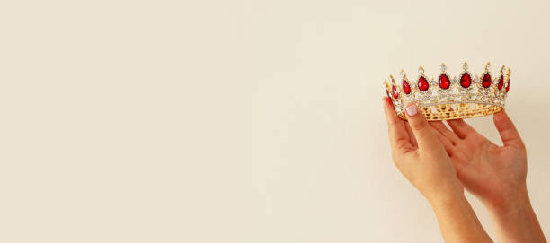 istock Woman's hand holding a crown for show victory or winning first place. White background. Copy space. Isolated. 903505606