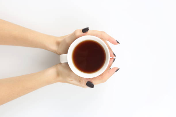 istock female hands with white tea Cup top view 903506124