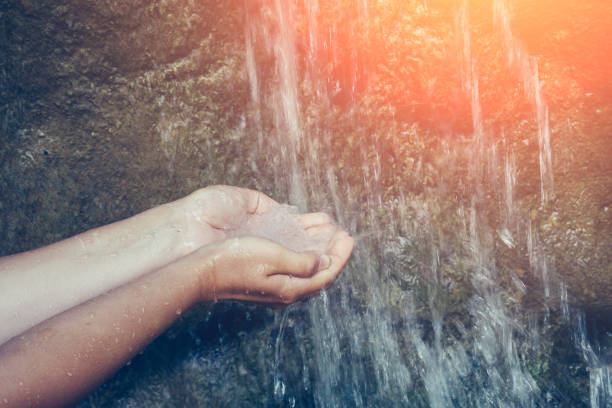 Female hands with water splash, mountain water pouring in girl arms with sunshine effect Female hands with water splash, mountain water pouring in girl arms with sunshine effect, toned splash mountain stock pictures, royalty-free photos & images