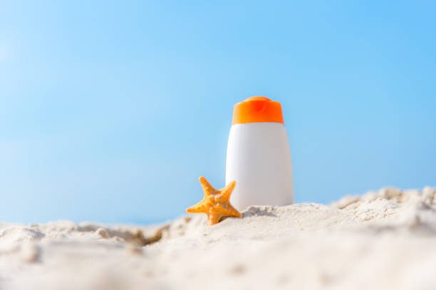 istock Protective sunscreen or sunblock and sunbath lotion in white plastic bottles on tropical beach, summer accessories in holiday, 903516766
