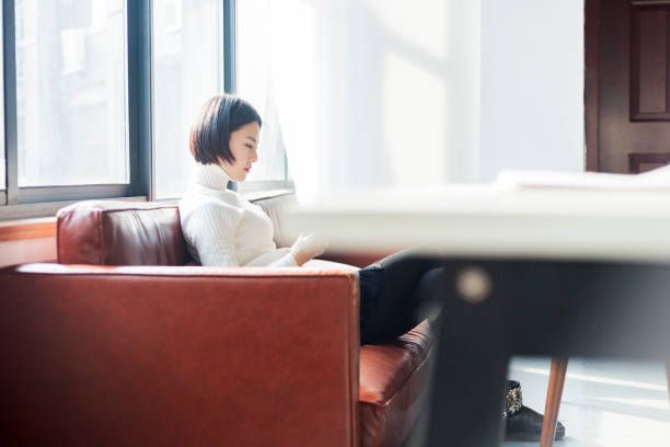 istock casual businesswoman relaxing on sofa using phone 903520454