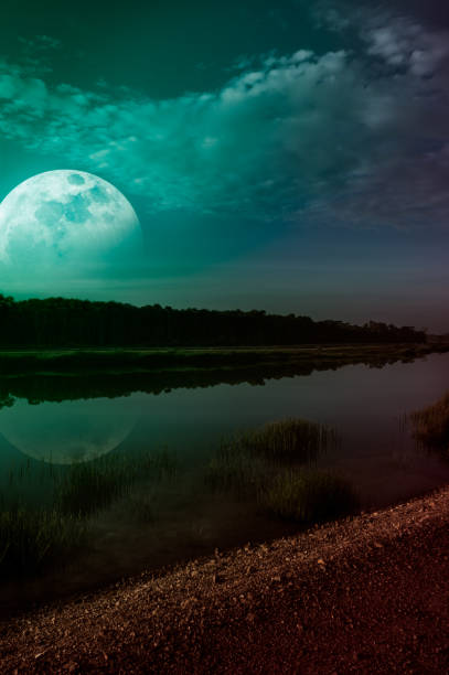 istock Emerald green sky and super moon at riverside. Serenity nature background. 903526796