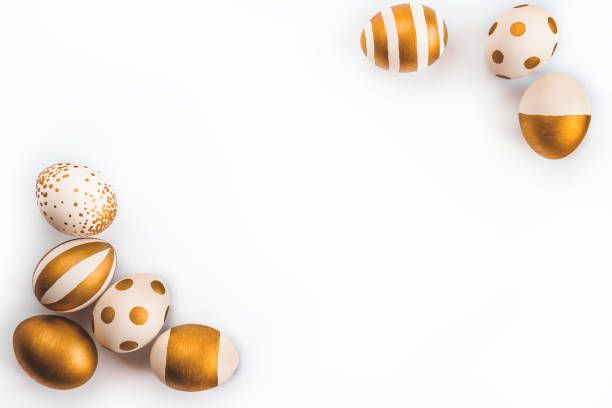 istock Top view of easter eggs colored with golden paint in differen patterns. Various striped and dotted designs. White background. Copy space. 903527256
