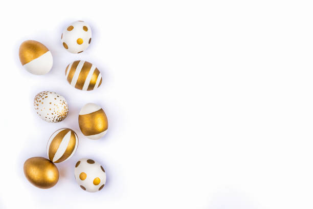 istock Top view of easter eggs colored with golden paint in differen patterns. Various striped and dotted designs. White background. Copy space. 903527276