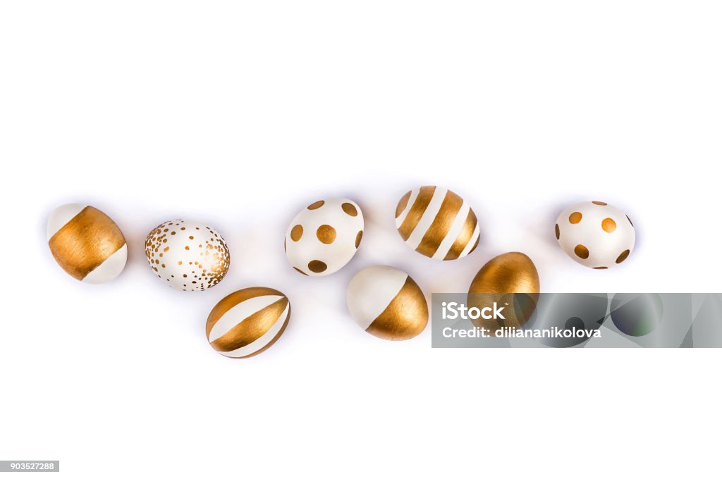 Top view of easter eggs colored with golden paint in differen patterns. Various striped and dotted designs. White background. Copy space. Easter Egg Stock Photo