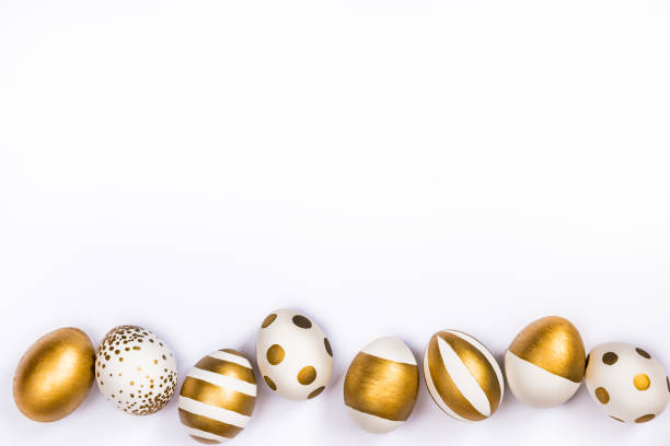 istock Top view of easter eggs colored with golden paint in differen patterns. Various striped and dotted designs. White background. Copy space. 903527302