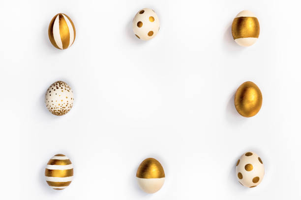 istock Top view of easter eggs colored with golden paint in differen patterns arranged in square. Various striped and dotted designs. White background. Copy space. 903527332