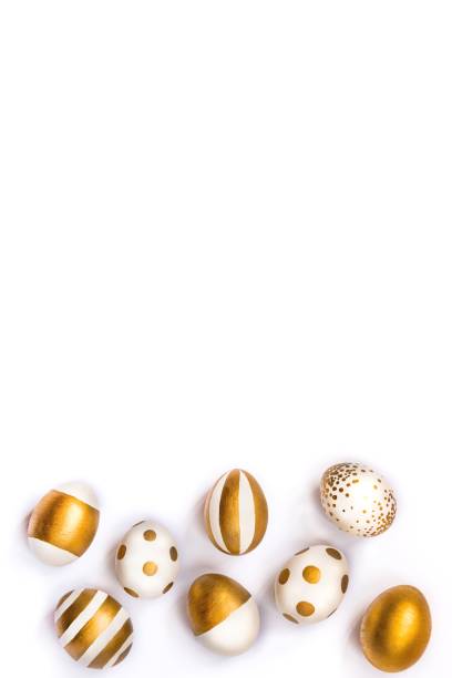 istock Top view of easter eggs colored with golden paint. Various striped and dotted designs. White background. 903527340