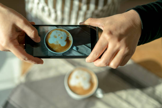 istock taking pictures of latte pattern with mobile phone 903530176