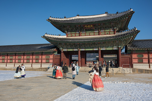 Seoul, Korea - January 10th 2018, Tourists wearing traditional Korean hanbok visit the Gyeongbokgung Palace at beautiful sunny winter day in Seoul Korea. 서울 경복궁