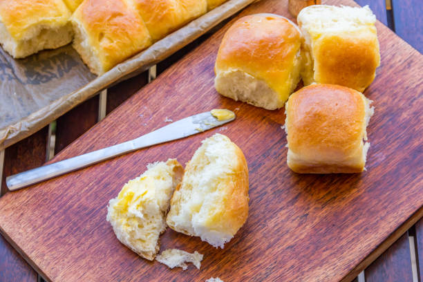 Freshly Baked Dinner Rolls Freshly Baked Dinner Rolls Served on Wooden Board With Butter Knife. yeast stock pictures, royalty-free photos & images