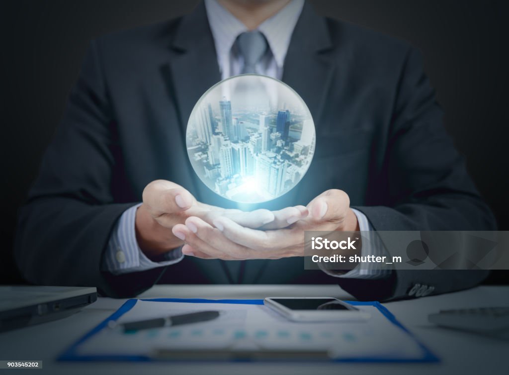 homme d’affaires main tenir la boule de cristal avec le bâtiment à l’intérieur - Photo de Boule de cristal libre de droits