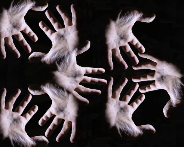 istock Chaotic view of human hands on dark background 903547736