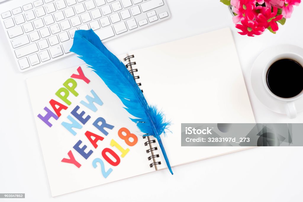 Palabras de feliz año nuevo 2018. Viwe superior de trabajo moderno con material de oficina, pluma azul, una taza de café y el teclado en fondo blanco. Diseño completamente laico. - Foto de stock de 2015 libre de derechos